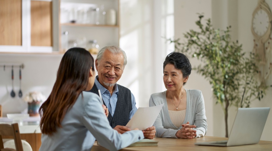 Elderly couple talking to financial advisor in kitchen