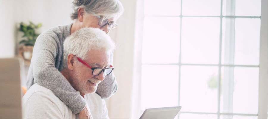 An older woman and husband looking at laptop together