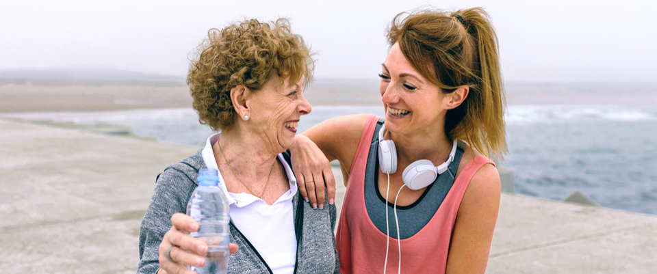 Two women outside exercising and smiling together