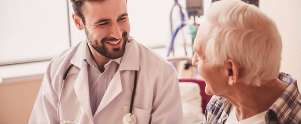 A physician talking to an older male patient