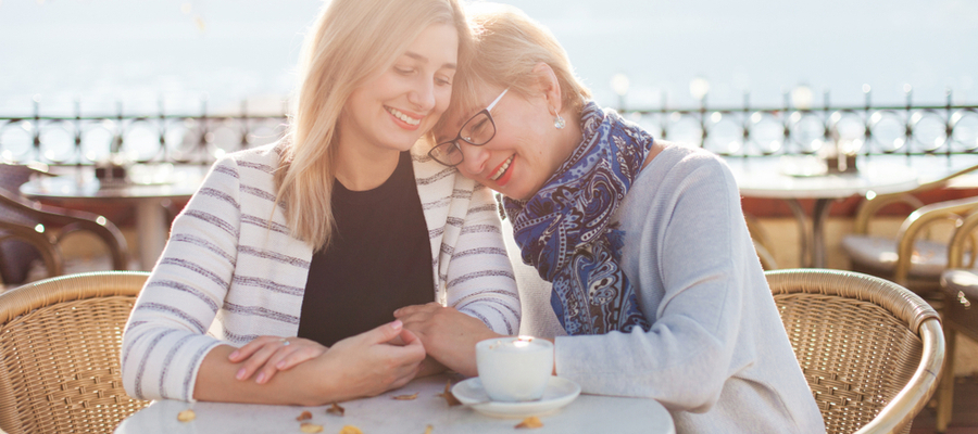 A mother and daughter sitting on a balcony at a café