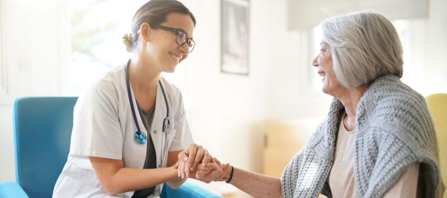 Healthcare provider talking to older woman about the current nationwide directive for social distancing amid coronavirus scare.