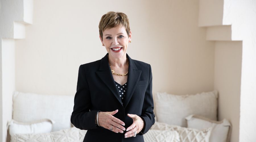 Pattie-Lovett-Reid-standing-and-smiling-in-black-suit