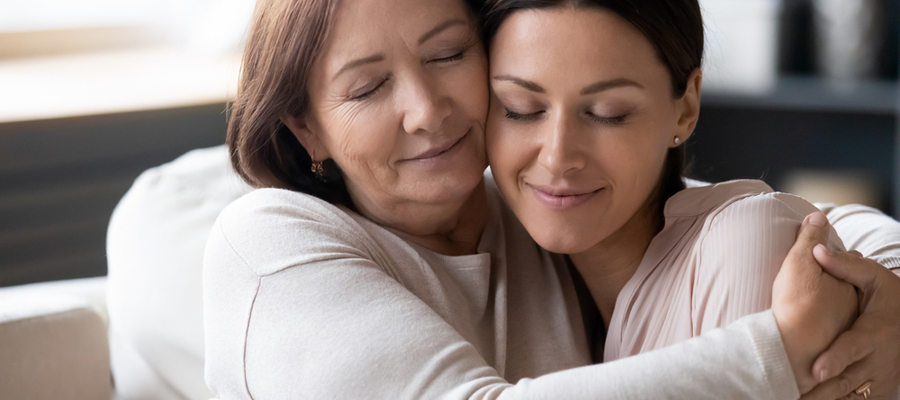 An older mother holding her daughter closely