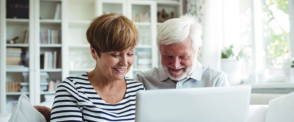 Senior couple comparing different home equity loan options and reverse mortgage to help them with the savings.