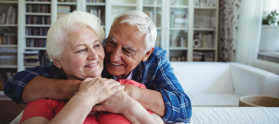 A husband wrapping his arms around his wife