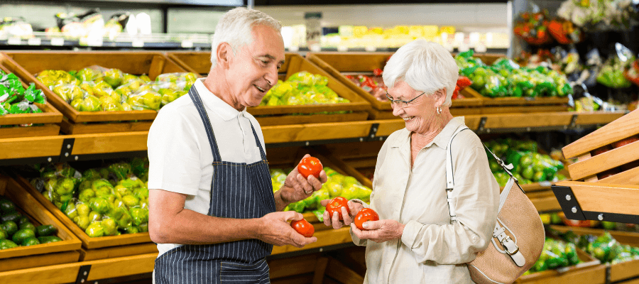 an-elderly-man-and-woman-happily-picking-vegetables-at-the-market
