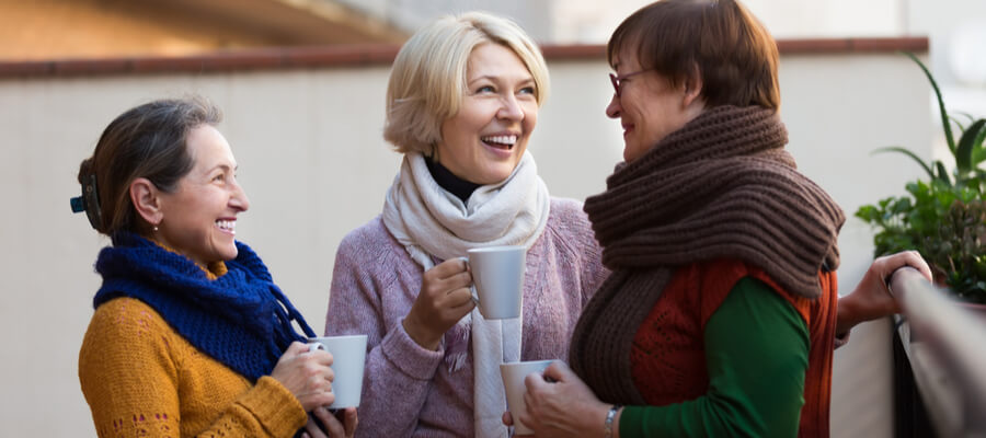 cheerful-senior-female-friends-conversing-over-coffee