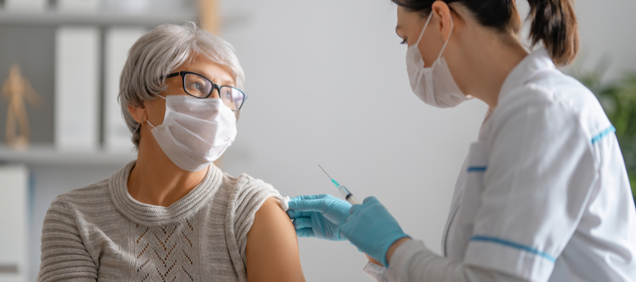 Doctor giving senior woman vaccination Covid virus