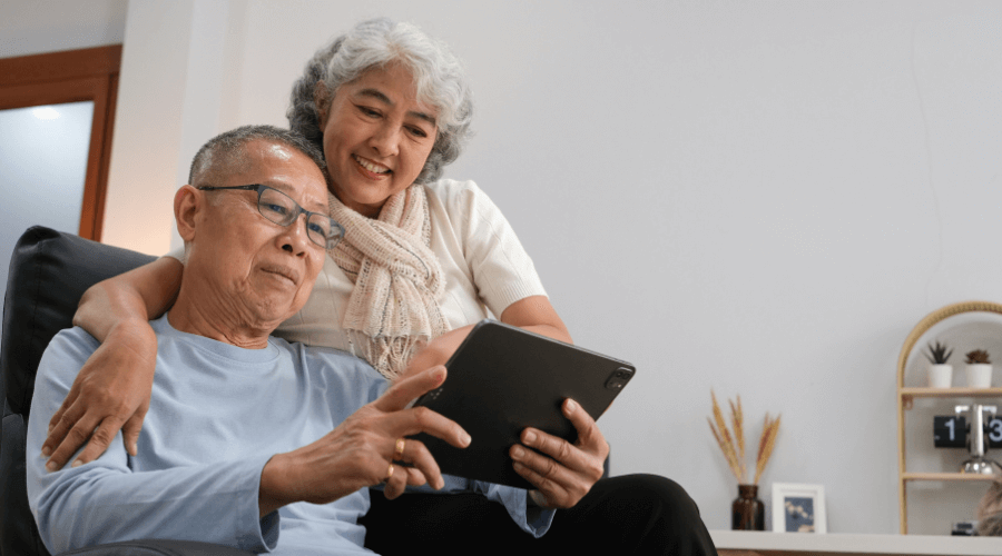 elderly Asian couple looking at their LIF policy in ipad