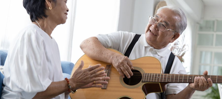 Elderly couple enjoying playing guitar