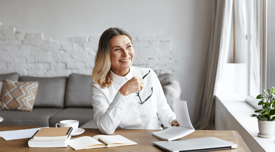 elderly-woman-in-her-home-reading-and-smiling