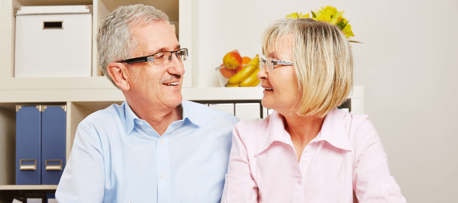 mature-couple-looking-at-each-other-and-smiling-talking-about-interest-rates