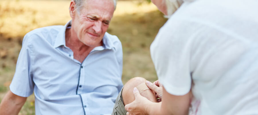 older-woman-applying-a-band-aid-on-an-older-man-with-an-injury