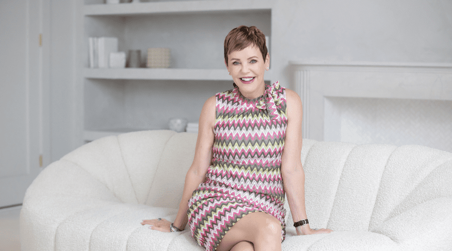 pattie-lovett-reid-sitting-and-smiling-in-pink-dress