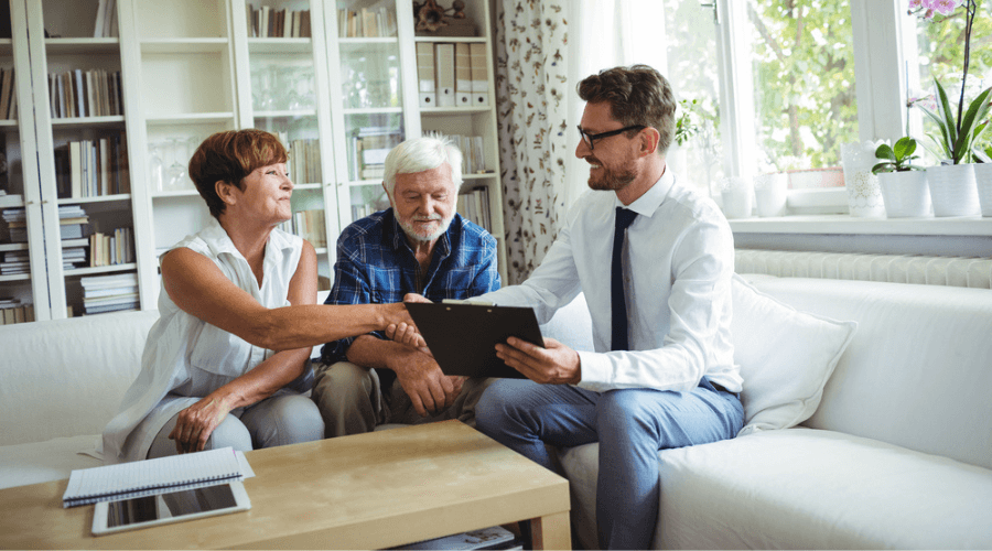 retired-couple-happily-shaking-hands-with-a-financial-advisor
