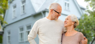 senior-couple-in-front-of-home