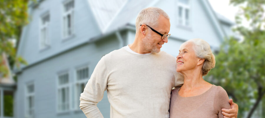 senior-couple-in-front-of-home