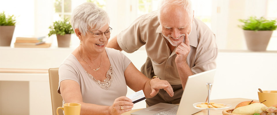 Senior couple reading information on how to secure CHIP Reverse Mortgage and how it will help them retain their home in Canada.