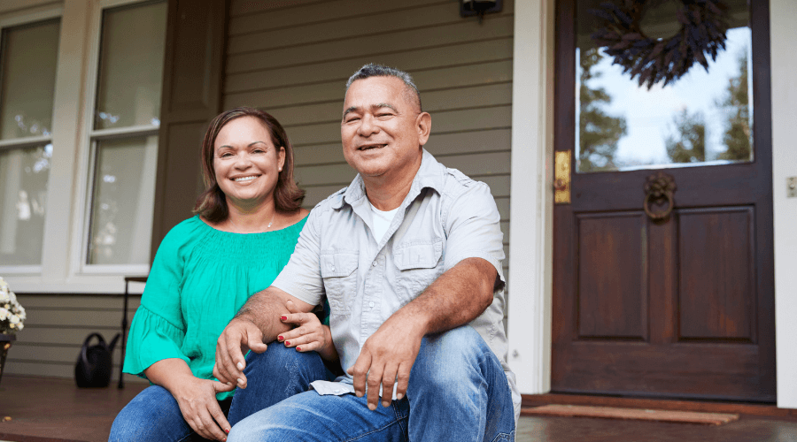 senior-couple-sitting-in-front-of-their-house