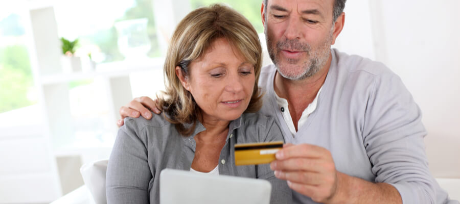 Middle aged couple using a credit card