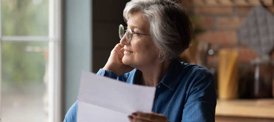 Thoughtful middle aged senior woman reviewing inheritance tax document