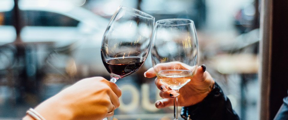 Two women celebrating their friendship over a glass of wine, comfortable with their retirement planning options.